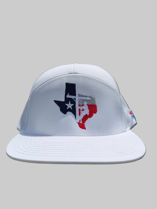 White cap with Texas design on grass and fence background